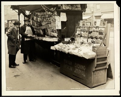 Blind news dealer, John Comuni, at his stand at 3rd Avenue and 18th Street, New York, 1926 by Byron Company
